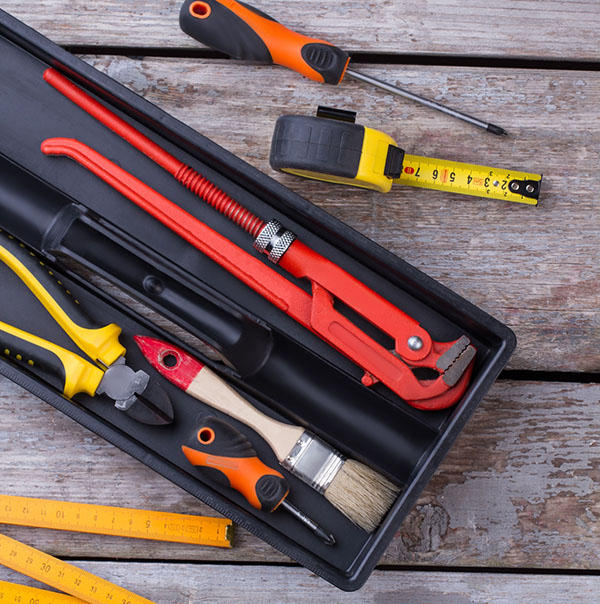 Tool box with different tools on wooden background. Various carpenter tools and instruments on wooden surface. Top view.